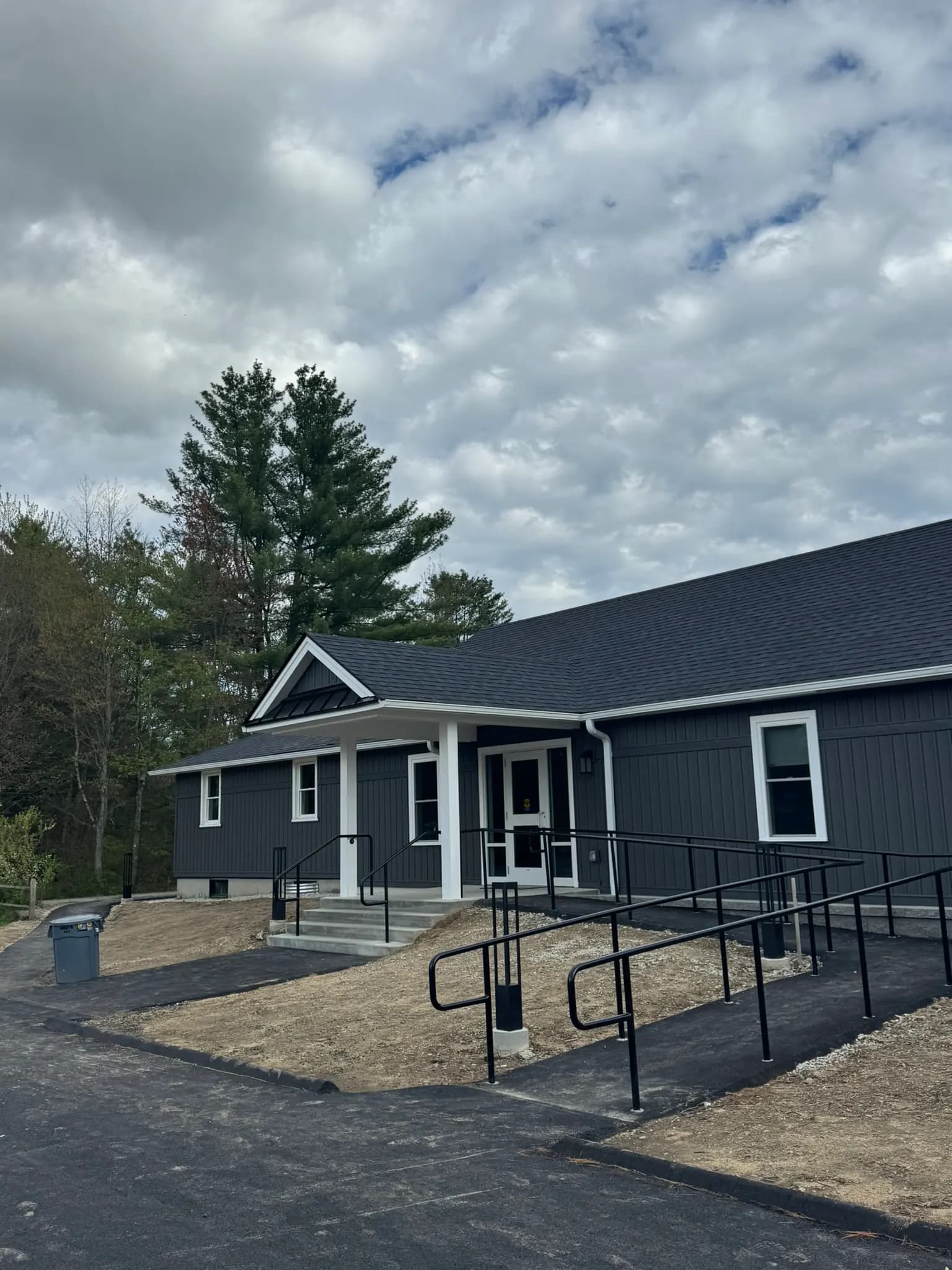 Dark blue siding and new roof installed by Veskon Builders on a commercial building in Massachusetts
